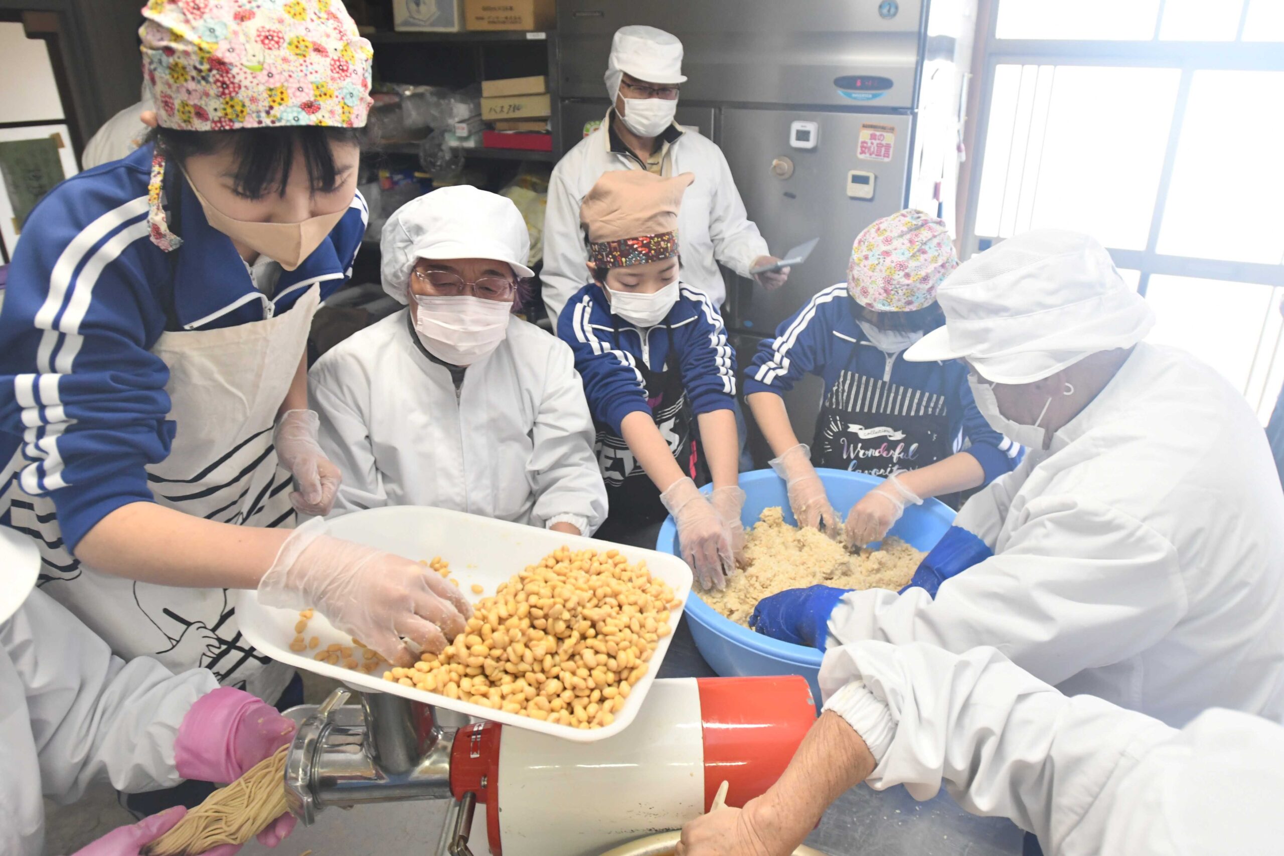 住民に交じって「長範みそ」を仕込む児童たち＝大垣市上石津町下山、時まちづくり会館